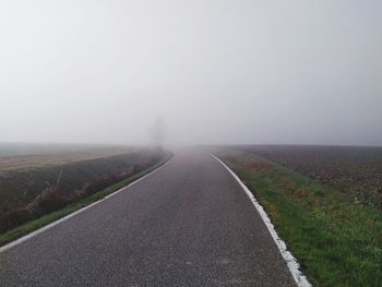 Empty road along landscape against sky