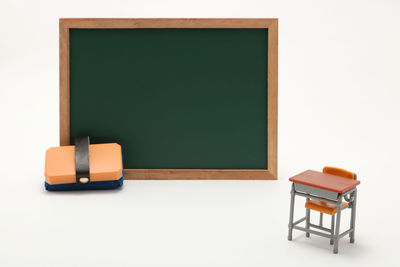 Close-up of miniature classroom equipment over white background