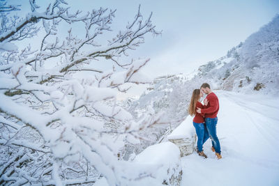 Full length of woman standing on snow covered mountain
