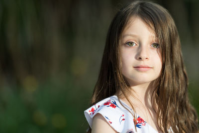 Portrait of cute girl with hazel eyes and brown hair outdoors