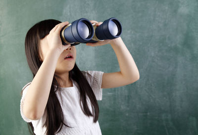 Close-up of girl looking through binoculars