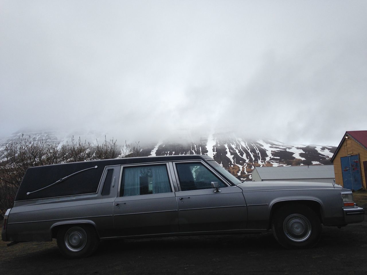 CAR ON ROAD AGAINST MOUNTAIN