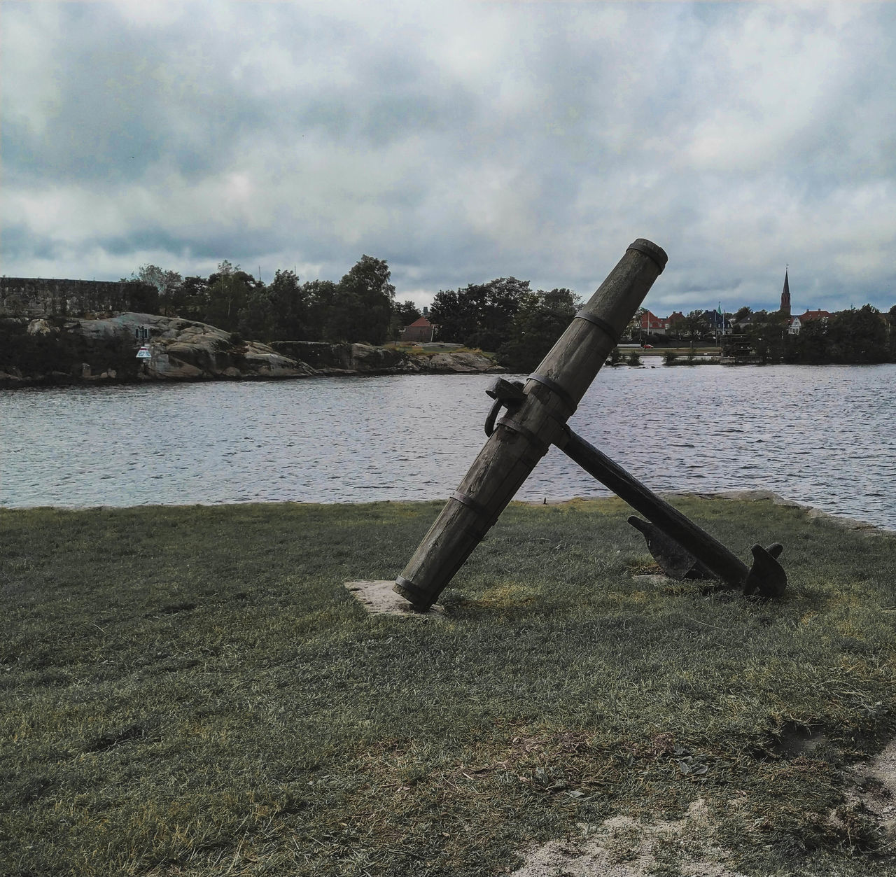 METALLIC STRUCTURE ON RIVERBANK AGAINST SKY