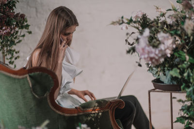 Girl holding plant at home