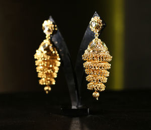 Close-up of gold earrings on table