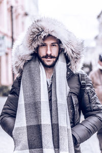 Portrait of young man standing in city