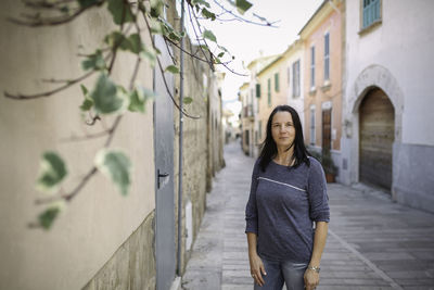 Portrait of woman standing against building