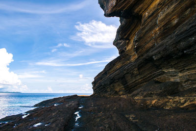 Rock formation on beach against sky