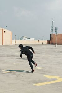 Full length of man skateboarding on wall against sky