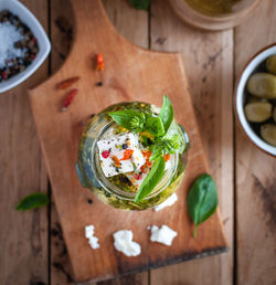 Close-up of marinated feta cheese in olive oil, herbs and red pepper flakes, top view