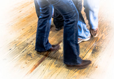 Low section of woman walking on wooden floor