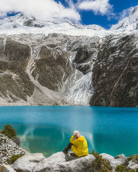 Man sitting on rock by sea