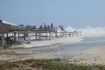 Pier on beach against sky