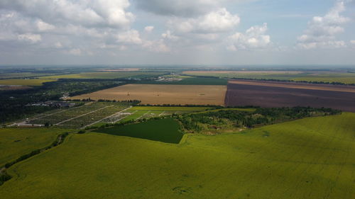 Green and yellow agricultural farm fields, fast moving shadows on the earth from white clouds 