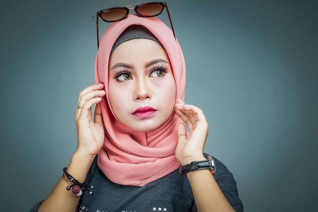 PORTRAIT OF A BEAUTIFUL YOUNG WOMAN OVER PINK BACKGROUND