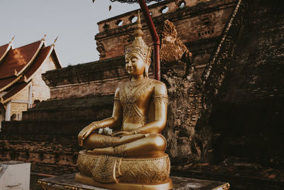 Statue of buddha against building