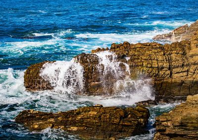 Scenic view of sea waves splashing on rocks