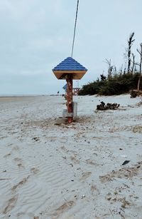 Lifeguard hut on beach against sky