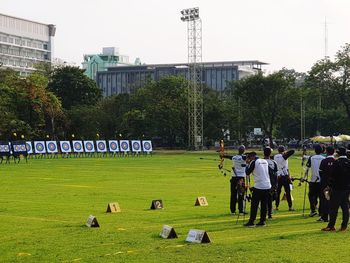 People on field against buildings