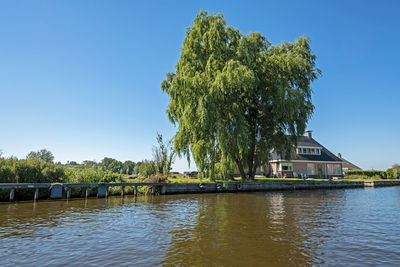 Typical dutch - farmers house in the countryside at a canal in the netherlands