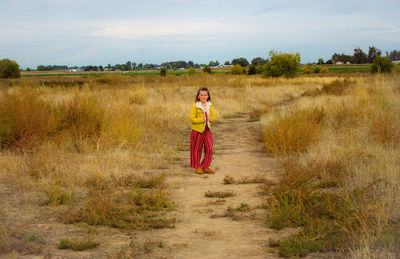 Full length of man standing on field against sky