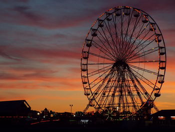 Low angle view of silhouette ferris wheel against sky at sunset