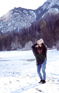 Full length of woman standing on snow covered land