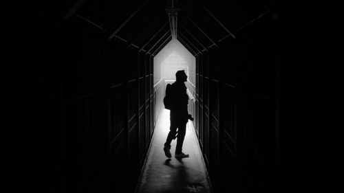 Man walking in corridor at night