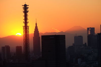 Silhouette buildings against sky during sunset