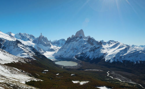 Scenic view of snowcapped mountains against clear blue sky