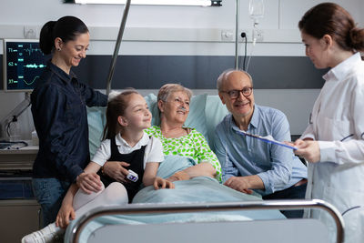 Side view of doctor explaining to daughter in car