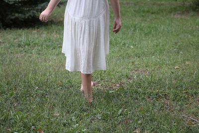 Low section of woman standing on field