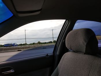 Rear view of car on road seen through window