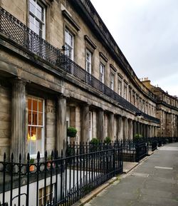 Buildings by street against sky