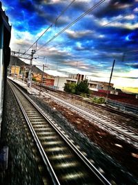 Railroad tracks against cloudy sky