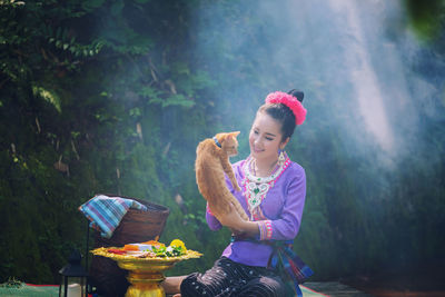Young woman holding cat