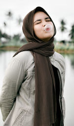 Young woman looking away while standing outdoors