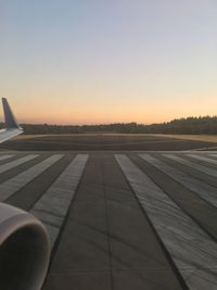 Airport runway against clear sky during sunset