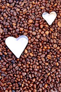 Full frame shot of roasted coffee beans with heart shape pastry cutters