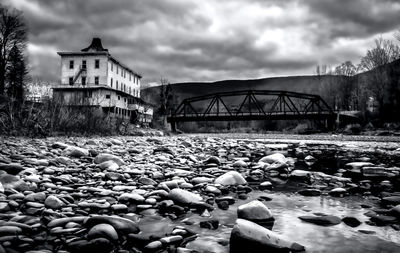 Surface level of stones by river against sky