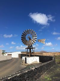 Traditional windmill on landscape against sky