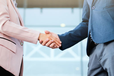 Midsection of business people shaking hands