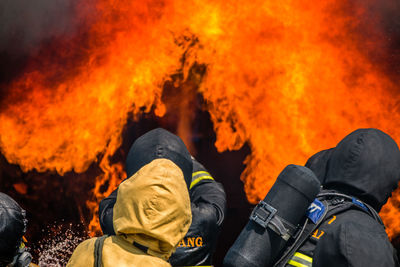 Rear view of firefighters extinguishing fire