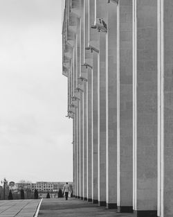 Low angle view of building and walking man against sky