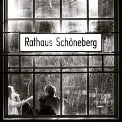 People at railroad station platform seen through window