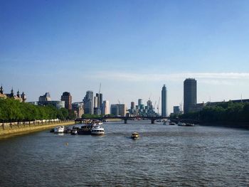 View of buildings by river against sky