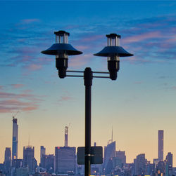 Modern buildings in city against sky during sunset