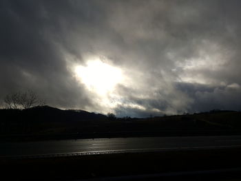 Silhouette of landscape against cloudy sky