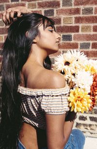 Midsection of woman with pink flower