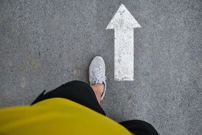 Low section of man standing on road